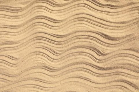 Top view of beach sand with wave pattern as background Stock Photos