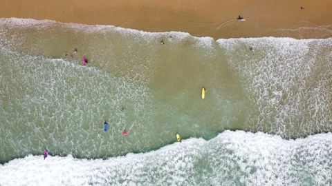 Top view beach with a surf school practicing in the waves Stock Footage 240045446