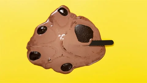 Top view bears paw shape chocolate flavor popsicle melting timelapse on yello Stock Footage 200798025