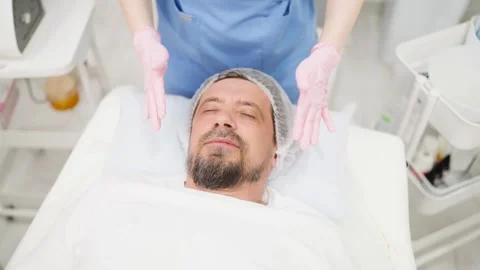 Top view of a beautician's hands in gloves giving a relaxing facial massage.. Stock Footage 345235881