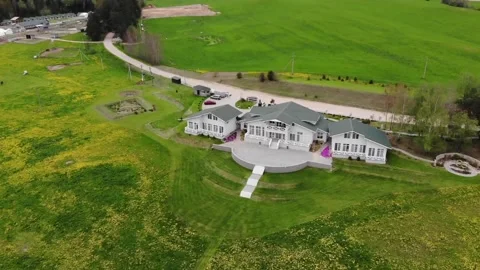 Top view of a beautiful cottage surrounded by green meadows with yellow flowers 库存影片 151341661