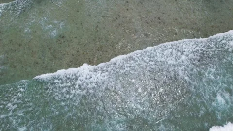 Top view of beautiful sand beach with azure seawater, wave passes, aerial shot Stock Footage 256456645