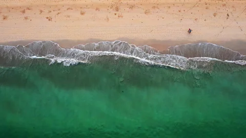Top view of beautiful sand beach along with person walking, emerald waves Stock Footage 294729069