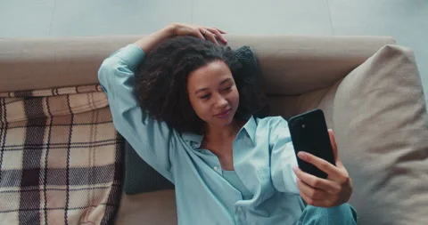 Top view beautiful young mixed race gen-z woman talks to friend using smartphone Video stock 148493759