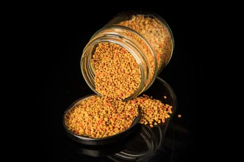 Top view on bee pollen grain poured out from glass jar Fotos de archivo