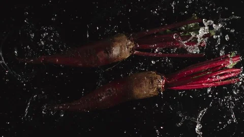 TOP VIEW: Beetroots fall in a water, splashing - Slow motion Видео 115319238