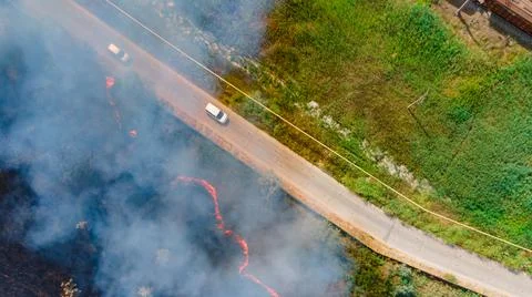 Top view at the beginning of the fire in a grassy field near the road Foto stock
