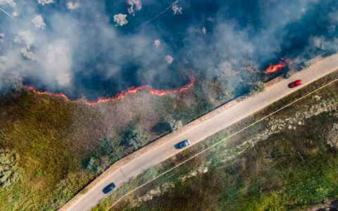Top view at the beginning of the fire in a grassy field near the road Stock Photos