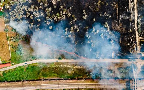 Top view at the beginning of the fire in a grassy field near the road Stock Photos