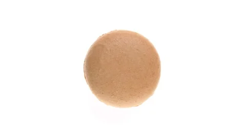 Top view of beige macaroon cookie rotating. Isolated on white background. Video stock 161056158
