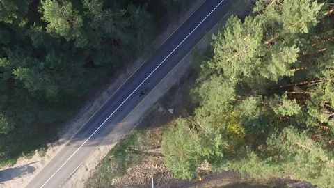 Top view of a biker riding a forest road, drone shot 库存影片 107657019