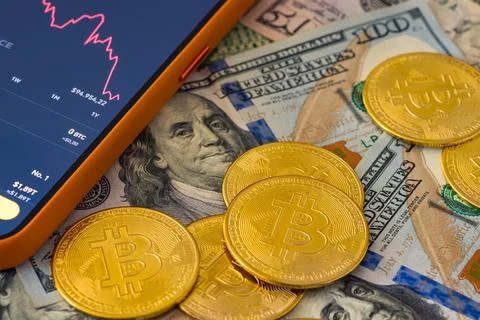 Top view of bitcoin coins lying on top of hundred dollar bills Stock Photos