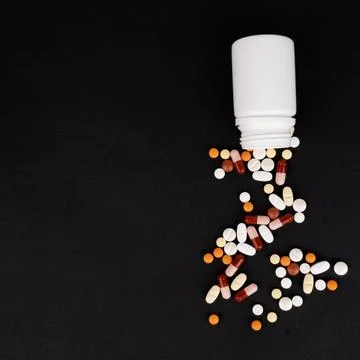 Top view black background with copy space. Spilled colorful drugs. Stock Photos