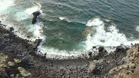 Top view of a black beach and the wavy sea at the volcanic rock coast of El H Stock Footage 193046198