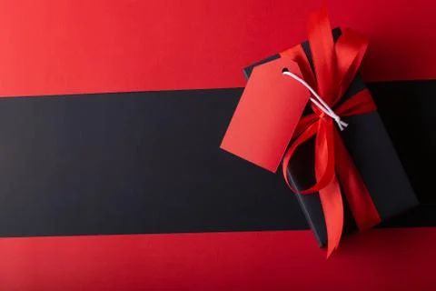 Top view of black boxes with red ribbon on black background and red backgroun Stock Photos