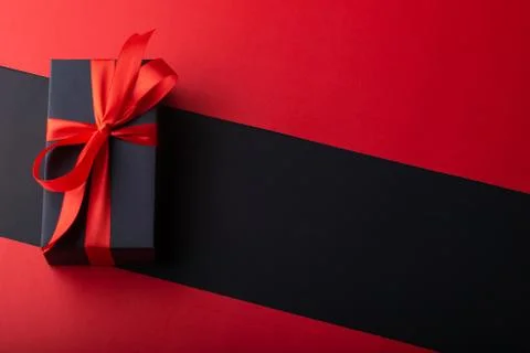 Top view of black boxes with red ribbon on black background and red backgroun Stock Photos
