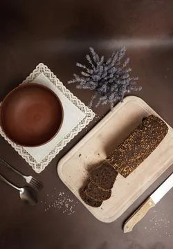 Top View Black Bread Sliced on cutting board against a brown background Stock Photos