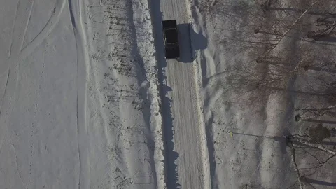 Top view with black car in winter with white snow on lonely road 스톡 동영상 128059081