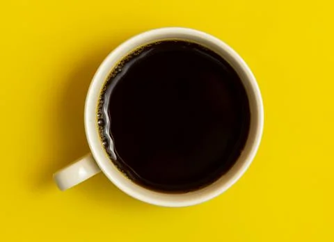 Top view of black coffee cup on yellow background Stock Photos