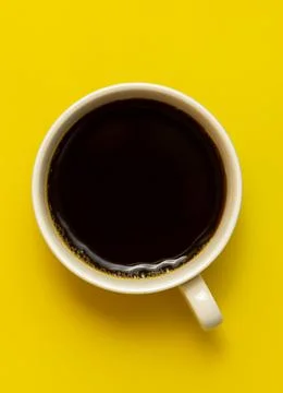 Top view of black coffee cup on yellow background Stock Photos