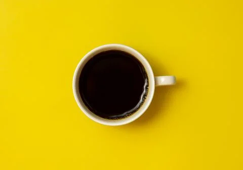Top view of black coffee cup on yellow background Stock Photos