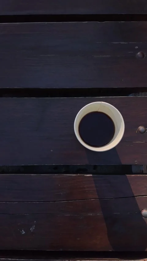 Top view of black coffee in a white cup on a wooden park bench Stock Footage 342980863
