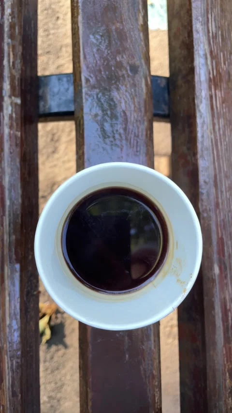Top view of black coffee in a white cup on a wooden park bench Stock Footage 342980864