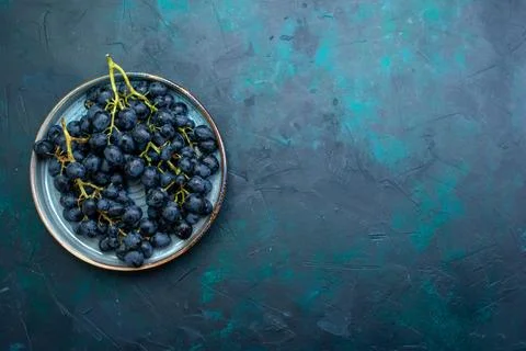 Top view black grapes on dark blue background fresh fruit mellow ripe tree Stock Photos