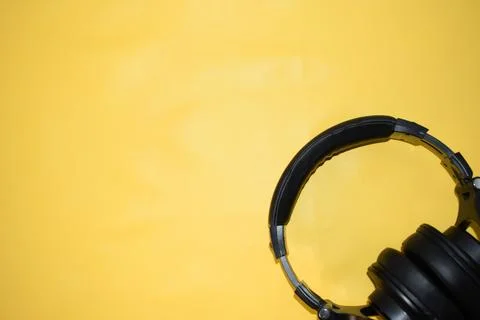 Top view black headphone with cable on yellow background Stock Photos