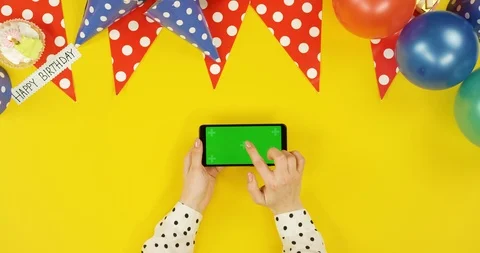 Top view on the black horizontal smartphone on the yellow table with birthday Stock Footage 89316752