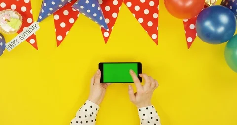 Top view on the black horizontal smartphone on the yellow table with birthday Stock Footage 89316878