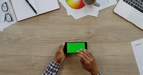 Top view of the black smartphone lying horizontally on the wooden office table Stock Footage 96003834