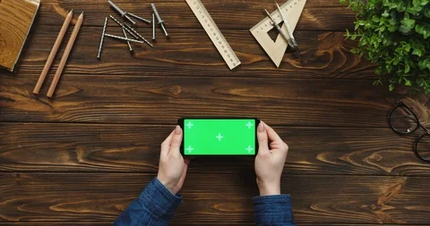 Top view on the black smartphone lying horizontally on the wooden table with Stock Footage 96018153