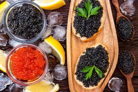 Top view of black surgeon and red salmon caviar on wooden table Stock Photos