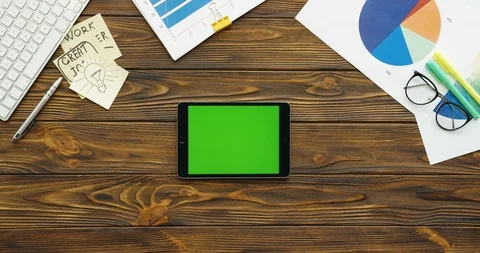 Top view on the black tablet device with a green screen lying horizontally on Stock Footage 88422503