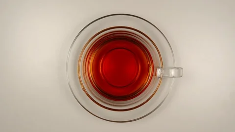 TOP VIEW: Black tea Drinking from a glass tea cup on a table - Stop motion Stock Footage 125290274