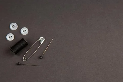 Top view black thread with buttons and pins on dark background work knit ph.. Foto stock
