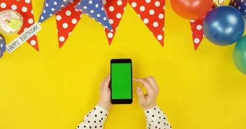 Top view on the black vertical smartphone on the yellow table with birthday Stock-Footage 89316937