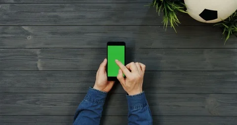 Top view on the black vertical smartphone with green screen in hands of man who 스톡 동영상 96307485
