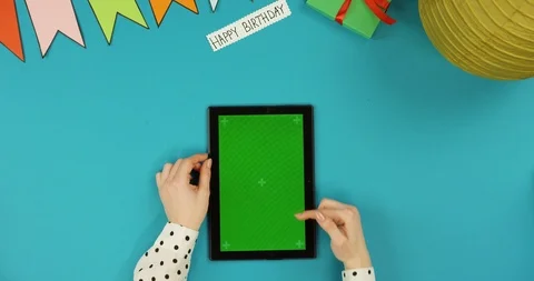 Top view on the black vertical tablet device lying on the blue table with Happy Stock-Footage 89312411