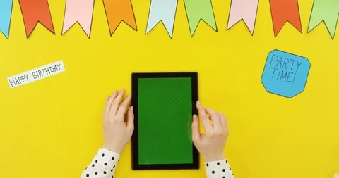 Top view on the black vertical tablet on the yellow table with decorations Stock-Footage 89333245