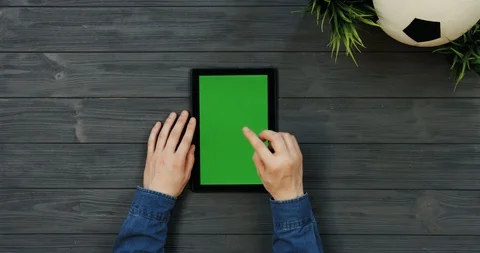 Top view on the black vertical tablet device with green screen in hands of man 스톡 동영상 96308878