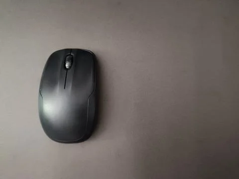 Top view of a black wireless computer mouse, placed on a gray surface. Stock Photos