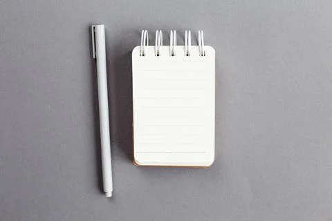 Top view of blank note paper with pen on gray background Foto stock