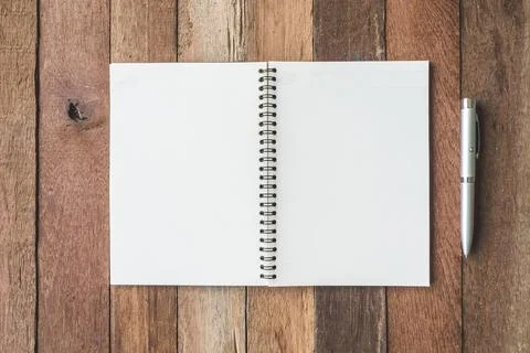 Top view of Blank notebook with pen on wooden table background. Stock Photos