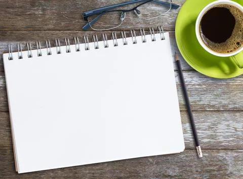 Top view blank notebook,glasses and coffee on wood table background on offi.. Stock Photos