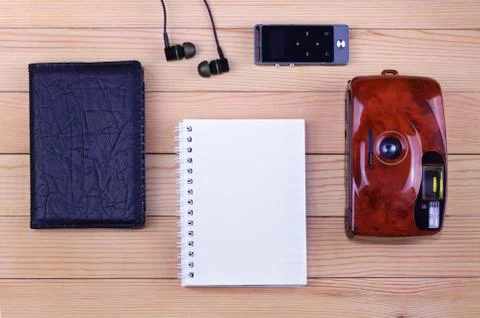 Top view: Blank notepad with old photo camera, black passport, earphones and mp3 Stock Photos