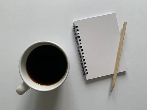 Top view of blank notepad, pen and coffee with white background. Stock Photos
