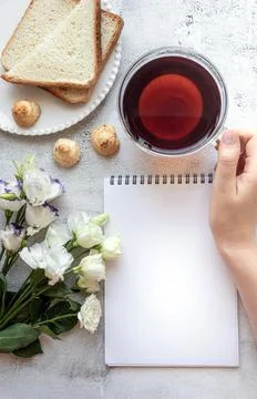 Top view of a blank notepad sheet and woman's hand in breakfast setting Stock Photos