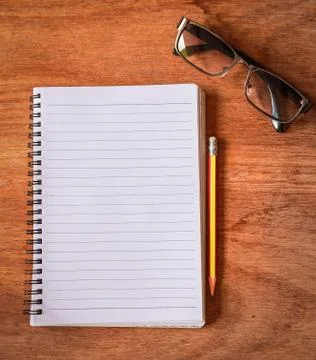 Top view from blank notepad workspace with pencil and glasses on wooden table Stock Photos